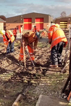 Image:- Volunteers working on the Level Crossing, digging old sleepers out.